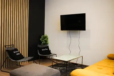 a living room with two chairs and a flat screen tv at Boho Privet Flat in Athens in Athens