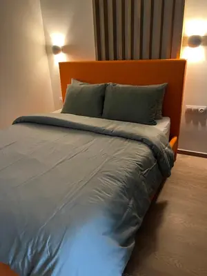 a bed with an orange headboard and two pillows at Boho Privet Flat in Athens in Athens