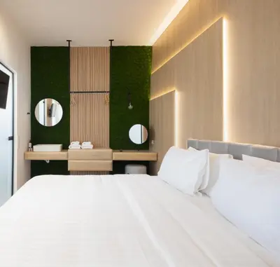 a bedroom with a large white bed and two mirrors at Incanto Boutique Suites - Neos Kosmos in Athens