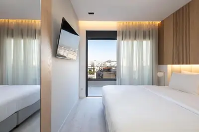 a hotel room with two beds and a window at Incanto Boutique Suites - Neos Kosmos in Athens