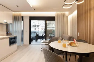 a kitchen and living room with a table and chairs at Incanto Boutique Suites - Neos Kosmos in Athens