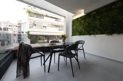 a dining room with a table and chairs on a balcony at Incanto Boutique Suites - Neos Kosmos in Athens