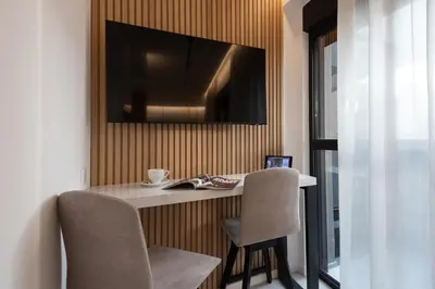 a desk with two chairs and a television on a wall at Incanto Boutique Suites - Neos Kosmos in Athens