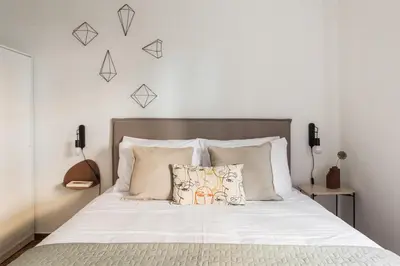 a bedroom with a bed with white sheets and pillows at Groovy 2BR Apartment in Koukaki by UPSTREET in Athens