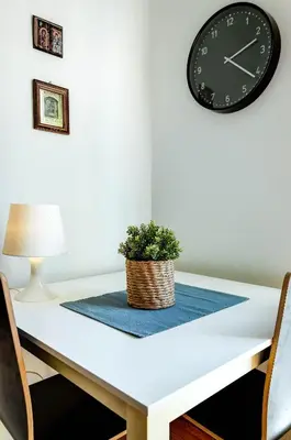 a table with a clock and a plant on it at Sunny all day apartment near Athens city center in Athens