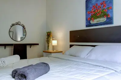 a bedroom with a large white bed and a mirror at Sunny all day apartment near Athens city center in Athens