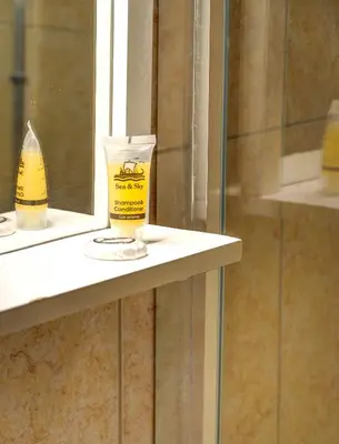 a bottle of toothpaste sitting on a shelf in a bathroom at Sunny all day apartment near Athens city center in Athens
