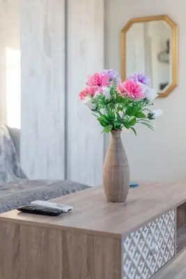a vase of flowers on a table with a mirror at Studio Acropolis Star in Athens