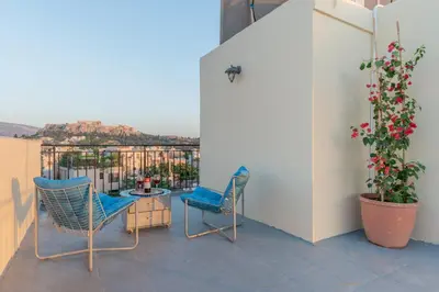 a patio with two chairs and a table on a balcony at Studio Acropolis Star in Athens
