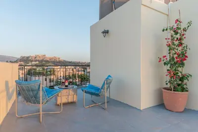 a patio with two chairs and a table on a balcony at Studio Acropolis Star in Athens