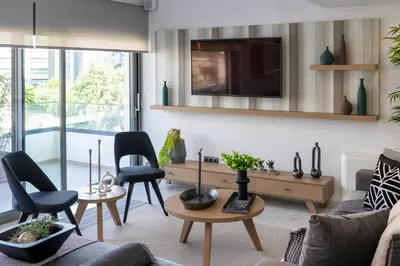 a living room with a couch and chairs and a tv at The Lop Athens Holidays Luxury Suites in Athens