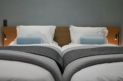 a large bed with two pillows on top of it at The Lop Athens Holidays Luxury Suites in Athens
