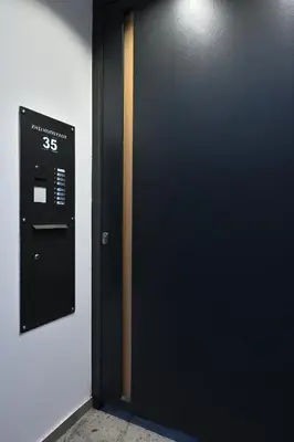 a black door with a sign on a wall at The Lop Athens Holidays Luxury Suites in Athens