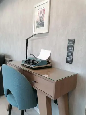 a desk with a keyboard and a blue chair at The Lop Athens Holidays Luxury Suites in Athens