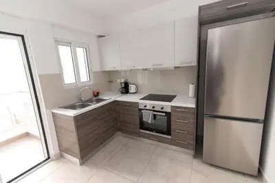 a kitchen with white cabinets and a stainless steel refrigerator at Lovely 2-bedroom apartment with a city view (F10) in Piraeus