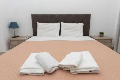 a bedroom with a bed with towels on it at Lovely 2-bedroom apartment with a city view (F10) in Piraeus