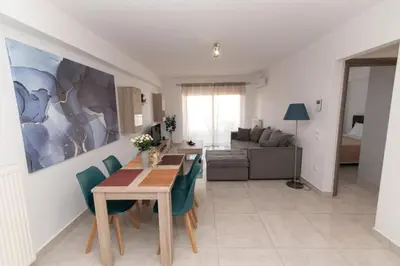 a living room with a table and chairs and a couch at Lovely 2-bedroom apartment with a city view (F10) in Piraeus
