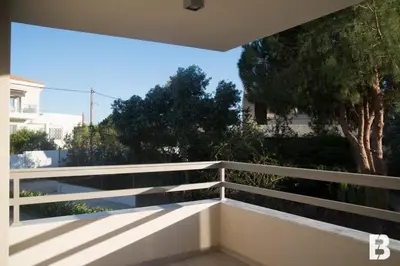 a balcony with a white railing and trees at Sia Mare in Kalívia Thorikoú