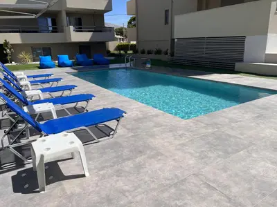 a pool with lounge chairs and a swimming pool at Sia Mare in Kalívia Thorikoú
