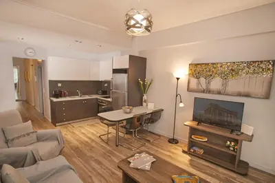 a living room with a couch and a table at Modern Hospitality- apt near Children's Hospital in Athens