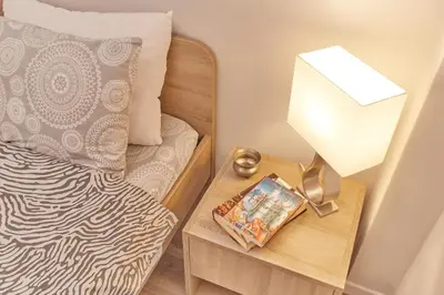 a bedroom with a bed and a table with a lamp at Modern Hospitality- apt near Children's Hospital in Athens