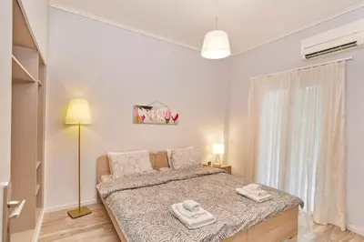 a bedroom with a bed with two towels on it at Modern Hospitality- apt near Children's Hospital in Athens