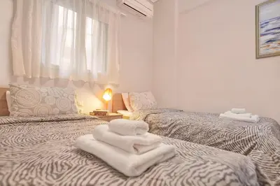 a room with two beds with towels on them at Modern Hospitality- apt near Children's Hospital in Athens