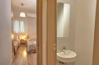 a bathroom with a sink and a bedroom with a bed at Modern Hospitality- apt near Children's Hospital in Athens