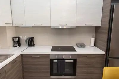a kitchen with white cabinets and a stove top oven at Comfy flat located in Piraeus (E7) in Piraeus