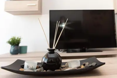a black vase sitting on a table with two cups at Comfy flat located in Piraeus (E7) in Piraeus