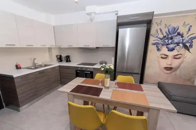 a kitchen with a wooden table and yellow chairs at Comfy flat located in Piraeus (E7) in Piraeus