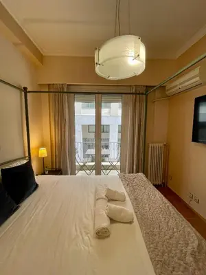 a bedroom with a large white bed with towels on it at Athens Spirit Apartment in Athens