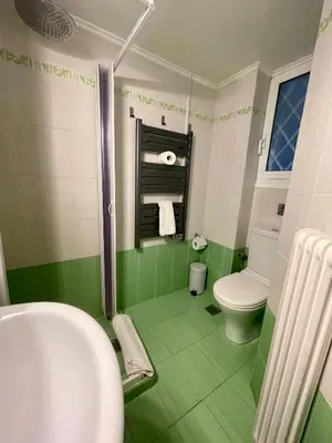 a green bathroom with a toilet and a sink at Athens Spirit Apartment in Athens