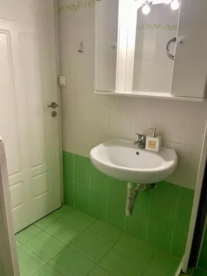 a bathroom with a sink and a green floor at Athens Spirit Apartment in Athens