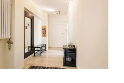 a living room with a black table and a white wall at Central faliro Apartment near to marina in Athens
