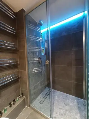 a shower with a glass door in a bathroom at Central faliro Apartment near to marina in Athens