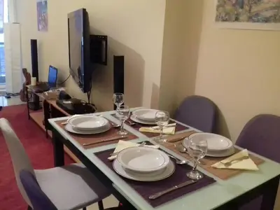 a dining table with plates and wine glasses on it at Central faliro Apartment near to marina in Athens
