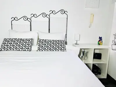 a bedroom with a white bed with black and white pillows at Cozy Studio in Athens Riviera, next to SNFCC in Athens
