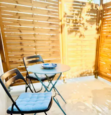 a table and two chairs on a porch with a table at Cozy Studio in Athens Riviera, next to SNFCC in Athens
