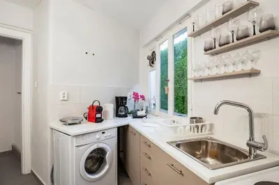 a white kitchen with a sink and a washing machine at Brand New Modern Street-Style STUDIO /CITY CENTER in Athens