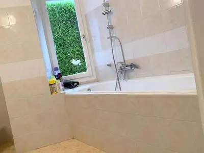a bathroom with a bath tub and a window at Brand New Modern Street-Style STUDIO /CITY CENTER in Athens