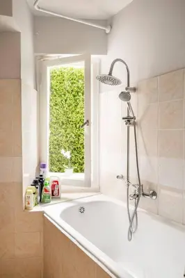 a bathroom with a bath tub and a window at Brand New Modern Street-Style STUDIO /CITY CENTER in Athens