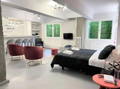 a bedroom with a black bed and a living room at Brand New Modern Street-Style STUDIO /CITY CENTER in Athens