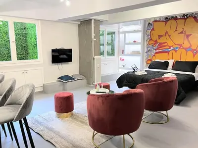 a living room with a bed and some chairs at Brand New Modern Street-Style STUDIO /CITY CENTER in Athens