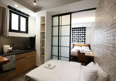 a room with a bed and a kitchen with a table at Emily in Athens - Central design awarded flat Syntagma E3 in Athens