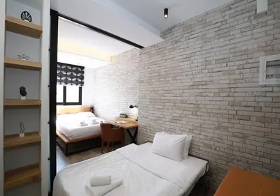 a bedroom with two beds and a brick wall at Emily in Athens - Central design awarded flat Syntagma E3 in Athens