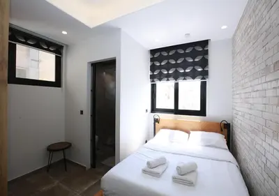 a bedroom with a white bed with two towels on it at Emily in Athens - Central design awarded flat Syntagma E3 in Athens