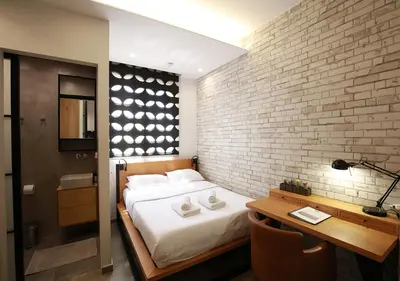 a bedroom with a bed and a brick wall at Emily in Athens - Central design awarded flat Syntagma E3 in Athens