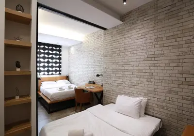 a bedroom with two beds and a brick wall at Emily in Athens - Central design awarded flat Syntagma E3 in Athens