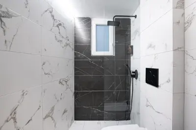 a bathroom with a shower with a toilet and a window at apt Eleven - cozy apartment with garden in Athens